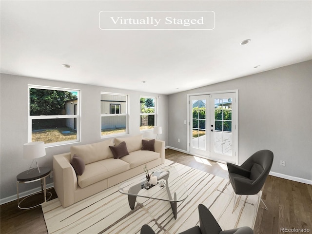 living room featuring hardwood / wood-style flooring, vaulted ceiling, and french doors