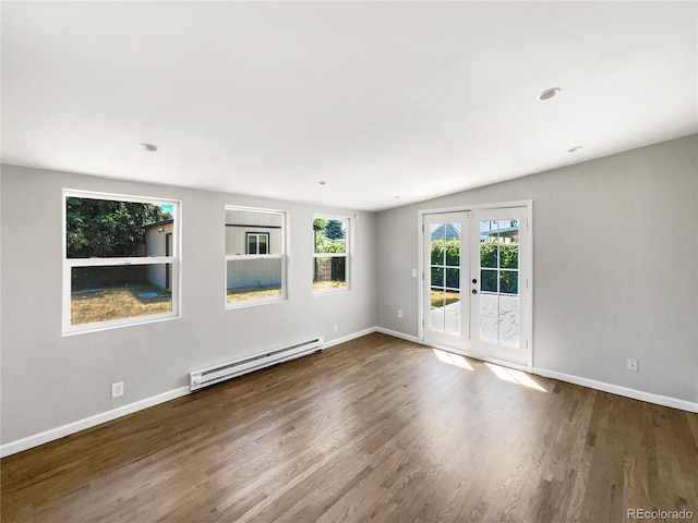 empty room featuring hardwood / wood-style flooring, baseboard heating, french doors, and vaulted ceiling