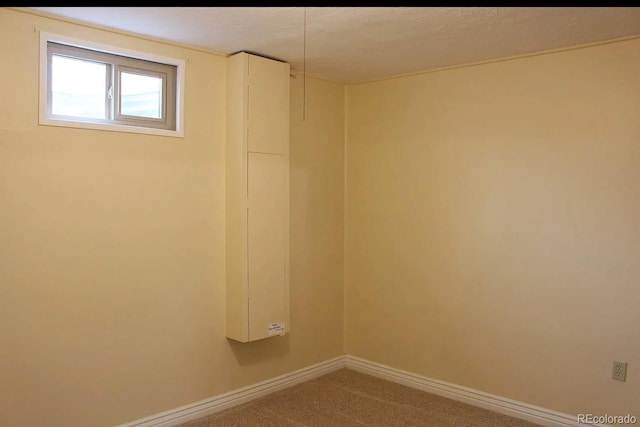 below grade area featuring carpet floors and baseboards