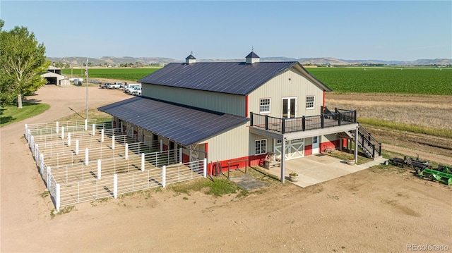 exterior space featuring a rural view, an outbuilding, and a mountain view