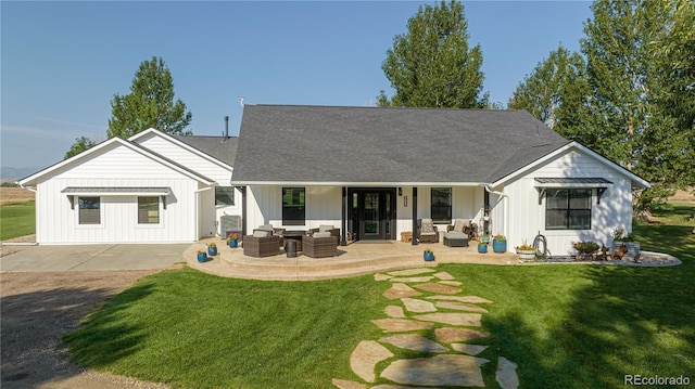 rear view of property featuring a patio area, a lawn, and an outdoor hangout area