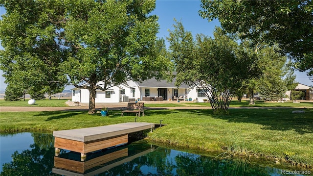 view of property's community with a water view and a lawn