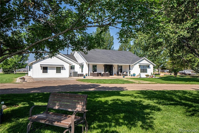 view of front facade with a front yard, an outdoor living space, and a patio area