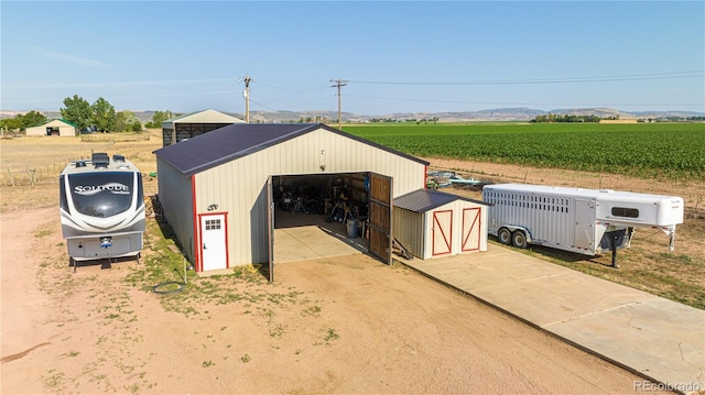 view of outdoor structure featuring a rural view and a garage