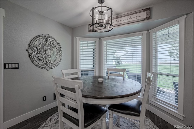 dining room with dark wood-type flooring and a chandelier