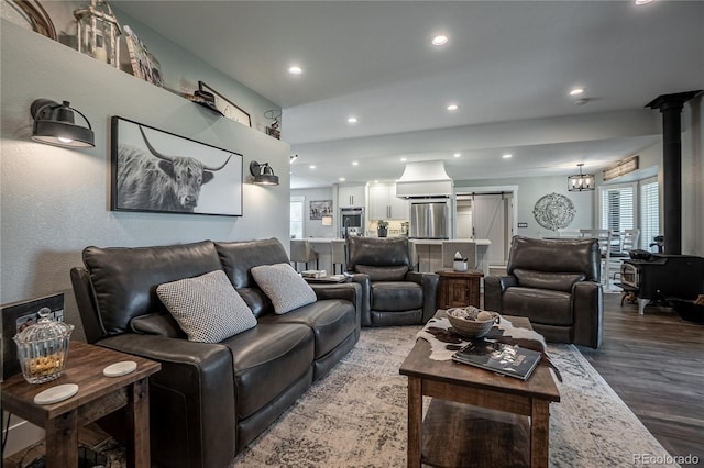 living room featuring an inviting chandelier, a barn door, and hardwood / wood-style floors