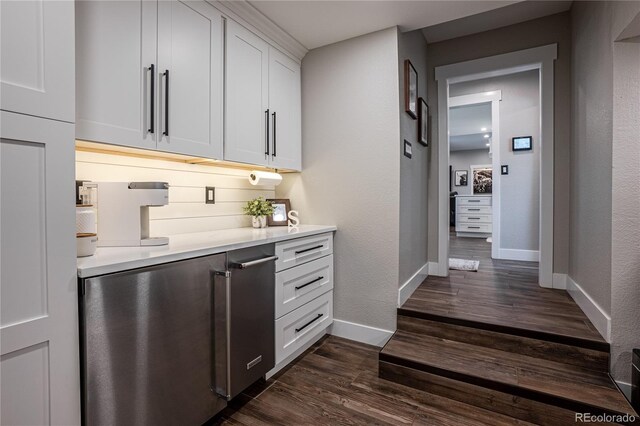 bar with dark hardwood / wood-style floors and white cabinetry