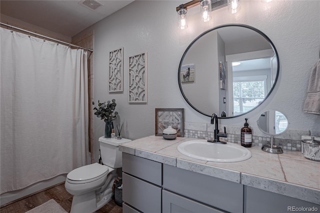 bathroom with toilet, vanity, and hardwood / wood-style floors