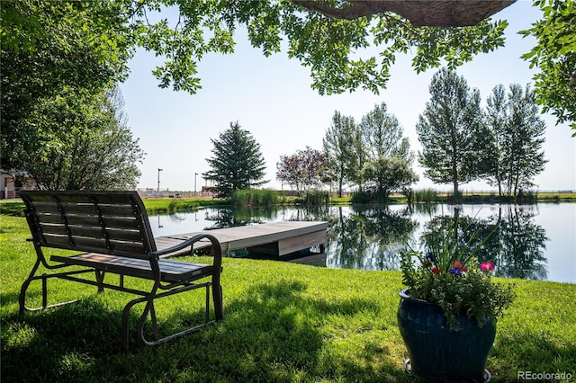 dock area with a water view and a lawn