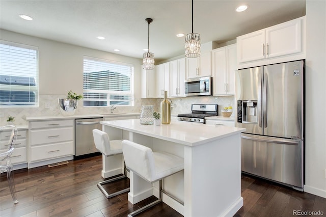 9180 E 52nd Dr, Denver, CO 80238 - kitchen featuring appliances with stainless steel finishes, a center island, dark wood-style floors, white cabinets, and recessed lighting
