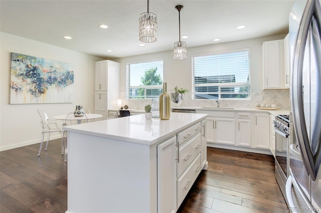 9180 E 52nd Dr, Denver, CO 80238 - kitchen with appliances with stainless steel finishes, dark wood-type flooring, white cabinetry, recessed lighting, and a center island