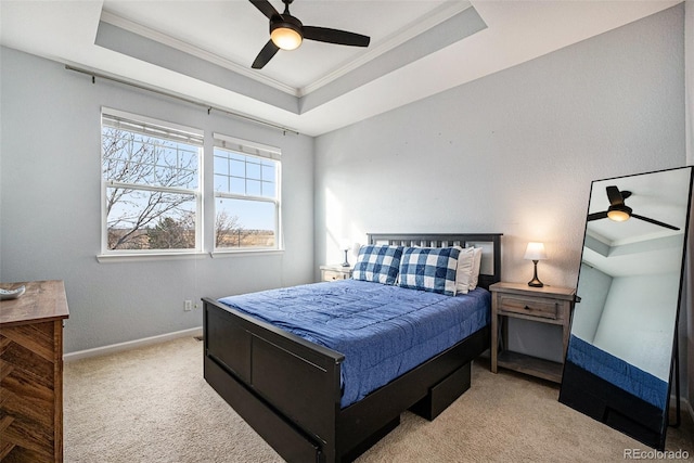 carpeted bedroom with a raised ceiling, ceiling fan, and crown molding