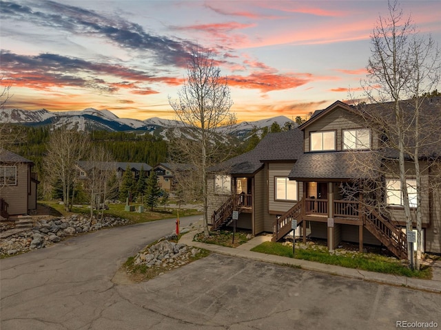 10 River Park Dr Unit A, Breckenridge, CO 80424 - view of front facade with stairway, a mountain view, a shingled roof, and covered porch