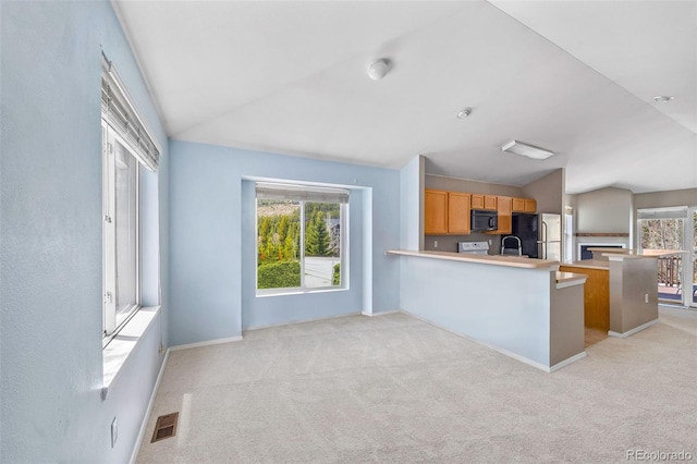 10 River Park Dr Unit A, Breckenridge, CO 80424 - kitchen featuring freestanding refrigerator, lofted ceiling, black microwave, a peninsula, and light colored carpet