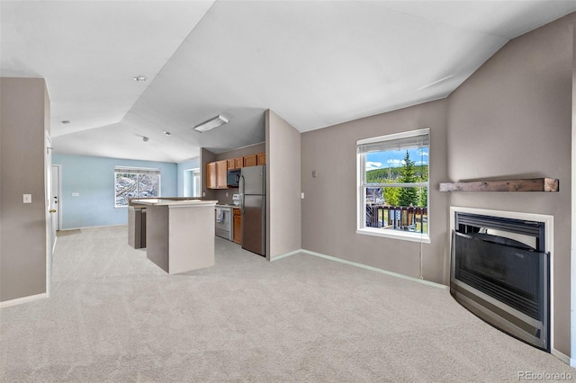 10 River Park Dr Unit A, Breckenridge, CO 80424 - kitchen with vaulted ceiling, freestanding refrigerator, a kitchen island, open floor plan, and light colored carpet