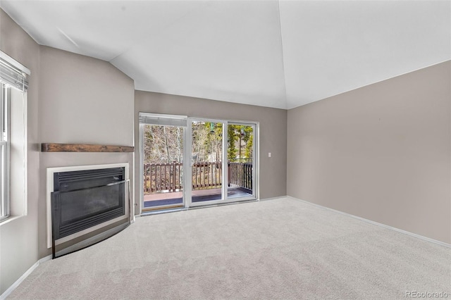 10 River Park Dr Unit A, Breckenridge, CO 80424 - unfurnished living room featuring lofted ceiling, a glass covered fireplace, carpet, and baseboards