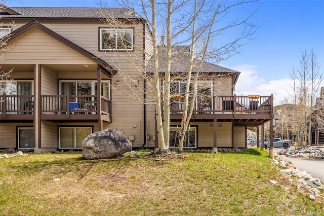 10 River Park Dr Unit A, Breckenridge, CO 80424 - rear view of house featuring roof with shingles, a deck, and a lawn