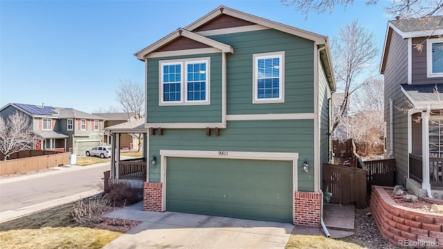 view of front facade with a garage, brick siding, concrete driveway, and fence