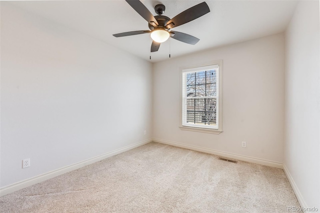 spare room with carpet flooring, visible vents, baseboards, and ceiling fan