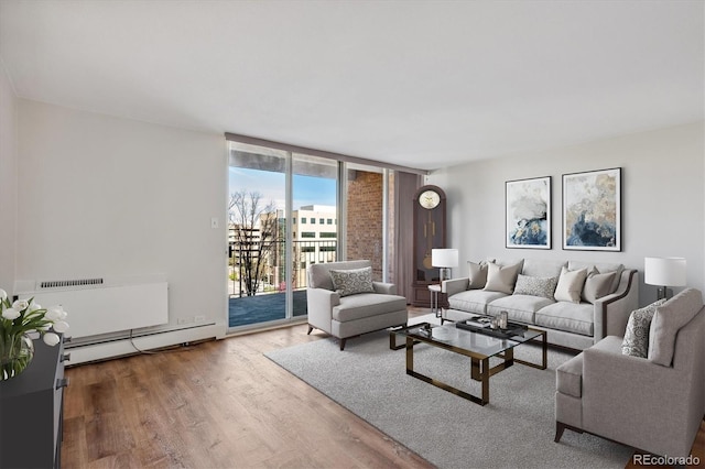 living room with floor to ceiling windows, hardwood / wood-style floors, and a baseboard radiator