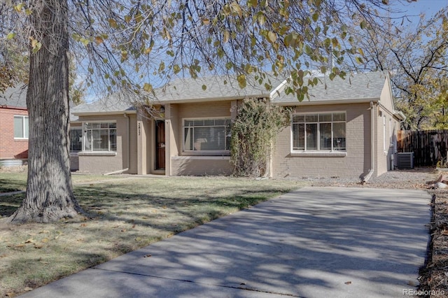 ranch-style house with a front yard and cooling unit