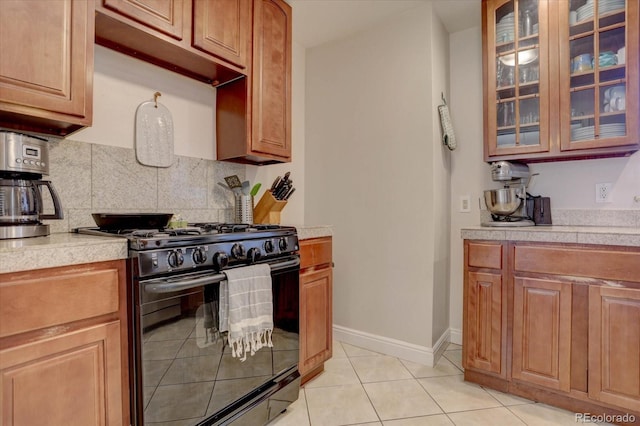 kitchen featuring tasteful backsplash, black gas range, and light tile patterned floors