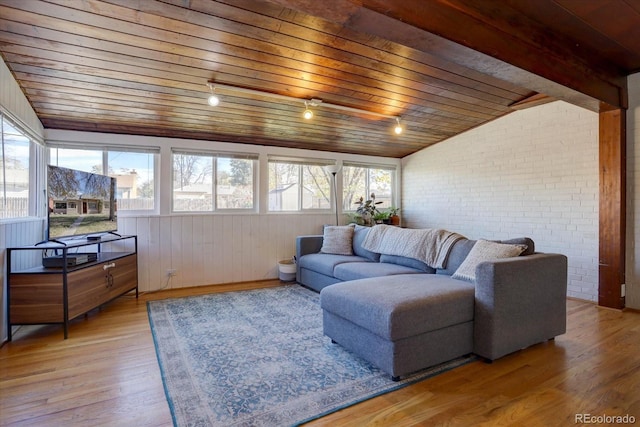 living room with a wealth of natural light, brick wall, hardwood / wood-style floors, and wooden ceiling