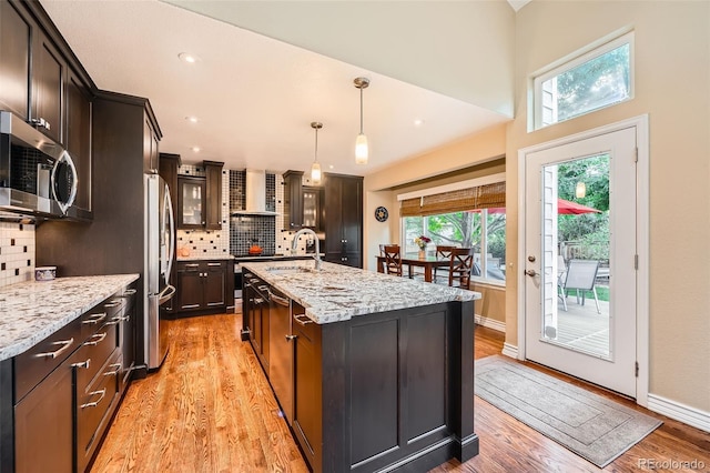 455 Bexley St, Littleton, CO 80126 - kitchen with stainless steel appliances, wall chimney exhaust hood, light wood-style flooring, backsplash, and recessed lighting