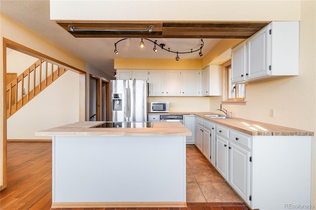 kitchen featuring white cabinetry, light hardwood / wood-style flooring, stainless steel refrigerator with ice dispenser, and sink