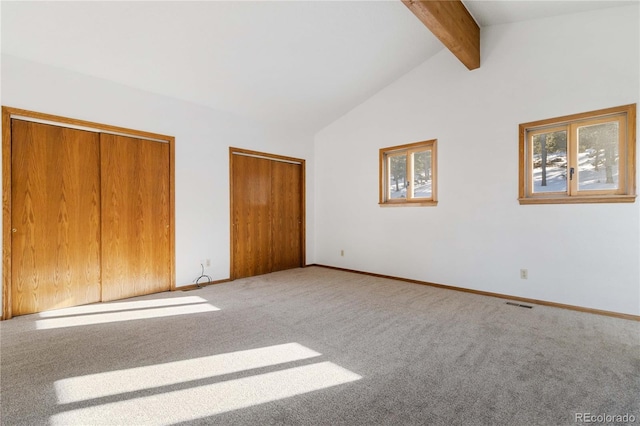 unfurnished bedroom featuring beamed ceiling, carpet floors, and high vaulted ceiling