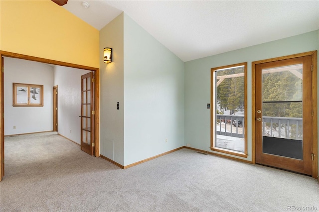 empty room featuring light colored carpet and vaulted ceiling