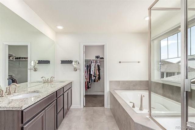 16321 Clayton St, Thornton, CO 80602 - full bath featuring a garden tub, a walk in closet, double vanity, tile patterned floors, and recessed lighting