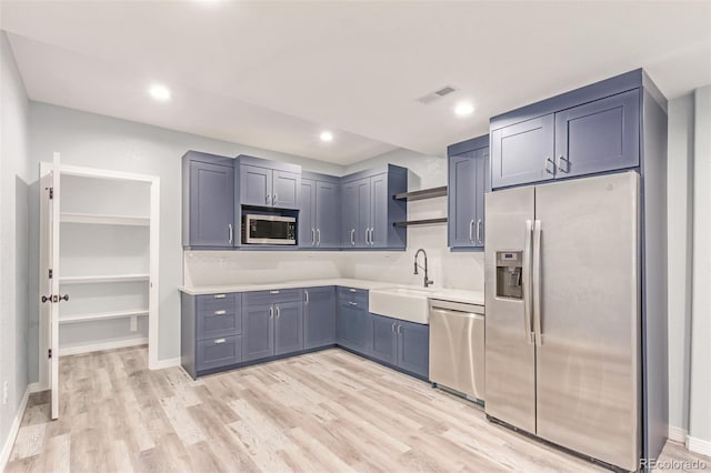 16321 Clayton St, Thornton, CO 80602 - kitchen with appliances with stainless steel finishes, open shelves, light countertops, light wood-style floors, and recessed lighting