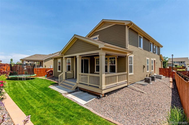 16321 Clayton St, Thornton, CO 80602 - back of property with a trampoline, a porch, and a fenced backyard