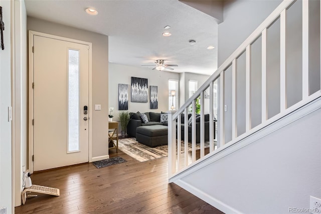 foyer featuring ceiling fan, dark hardwood / wood-style flooring, and a textured ceiling