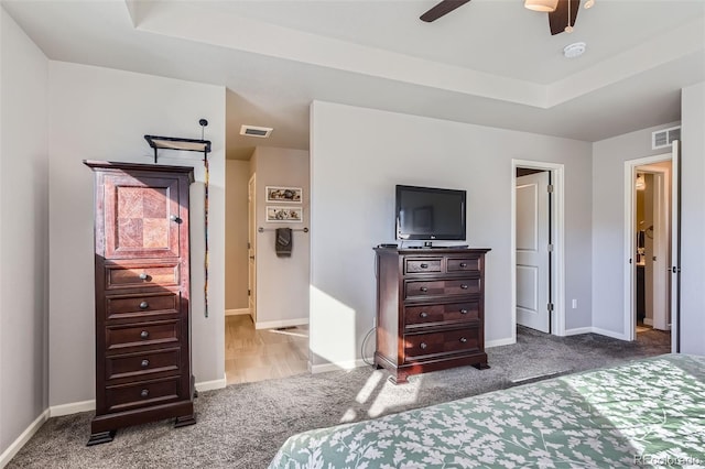 bedroom with ceiling fan, a raised ceiling, and carpet floors