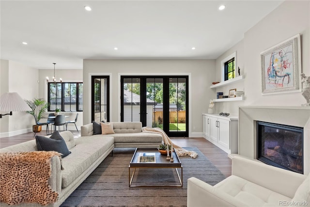 living room with a notable chandelier and dark wood-type flooring