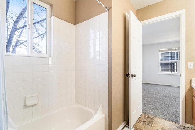 bathroom with vanity, tiled shower / bath, and a healthy amount of sunlight