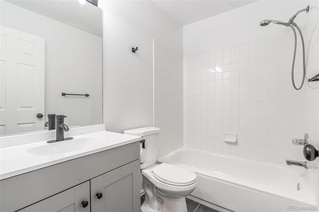 full bathroom featuring vanity, tiled shower / bath, tile patterned flooring, and toilet