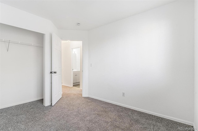 unfurnished bedroom featuring carpet and a closet