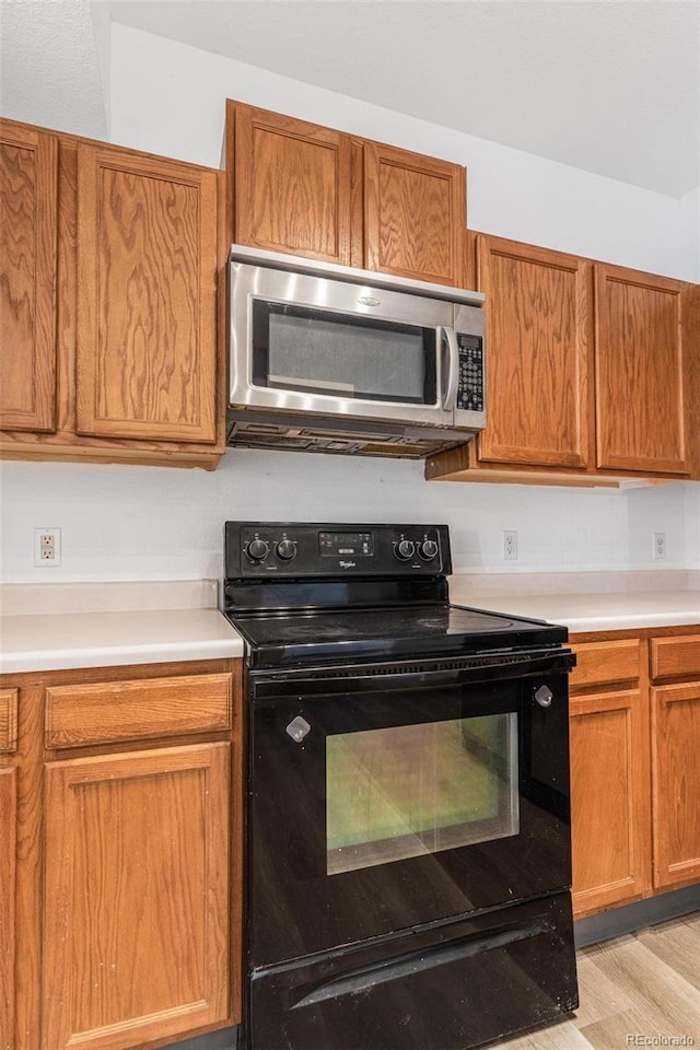 kitchen featuring black range with electric cooktop and light wood-type flooring