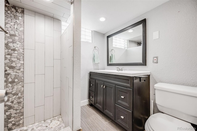 7350 Dale Ct, Westminster, CO 80030 - full bathroom featuring vanity, a tile shower, a textured wall, and recessed lighting
