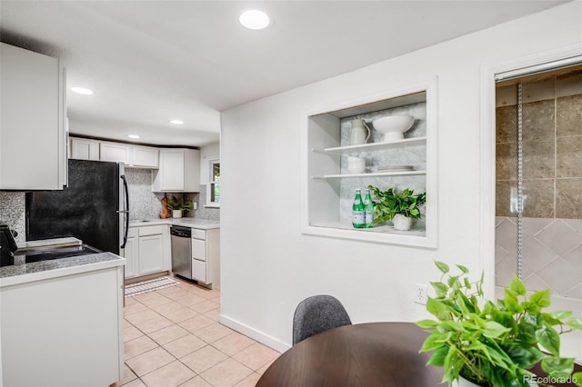 7350 Dale Ct, Westminster, CO 80030 - kitchen with dishwasher, white cabinetry, light tile patterned floors, freestanding refrigerator, and backsplash