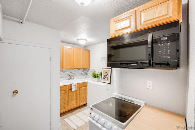 7350 Dale Ct, Westminster, CO 80030 - kitchen with stove, black microwave, backsplash, a textured ceiling, and light countertops