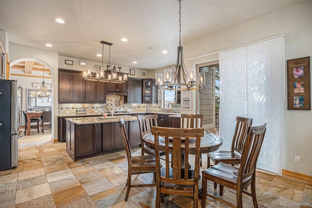12161 S Leaning Pine Ct, Parker, CO 80134 - dining area with recessed lighting, arched walkways, a chandelier, and stone tile flooring