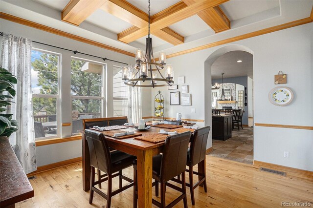12161 S Leaning Pine Ct, Parker, CO 80134 - dining room featuring a notable chandelier, arched walkways, beamed ceiling, visible vents, and coffered ceiling