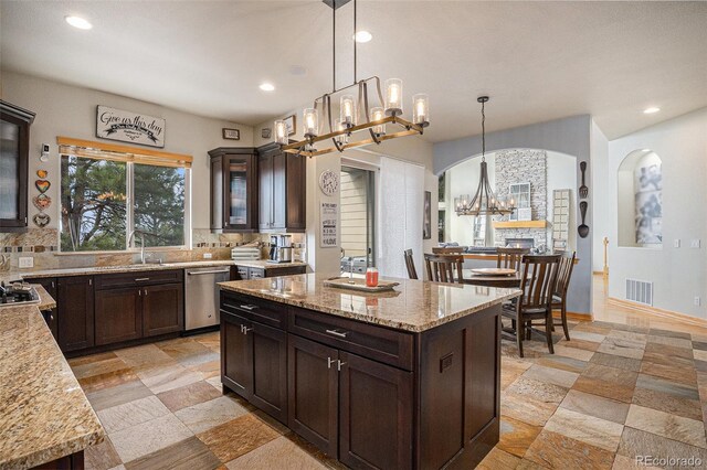 12161 S Leaning Pine Ct, Parker, CO 80134 - kitchen with an inviting chandelier, visible vents, dark brown cabinets, arched walkways, and dishwasher
