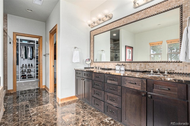 12161 S Leaning Pine Ct, Parker, CO 80134 - bathroom featuring visible vents, double vanity, marble finish floor, a walk in closet, and backsplash