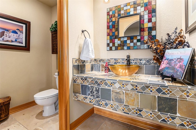 12161 S Leaning Pine Ct, Parker, CO 80134 - bathroom featuring a sink, tile patterned flooring, toilet, baseboards, and backsplash