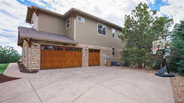 12161 S Leaning Pine Ct, Parker, CO 80134 - view of property exterior featuring a garage, concrete driveway, central AC, and stone siding